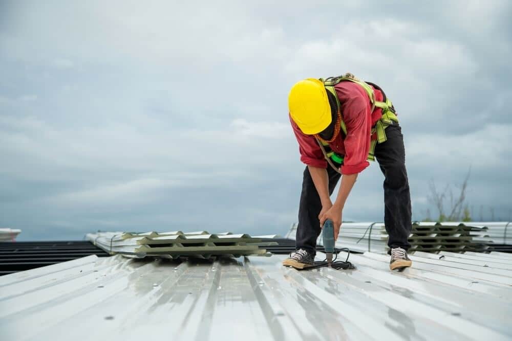 Roofer replacing section of flat roof in Albuquerque.