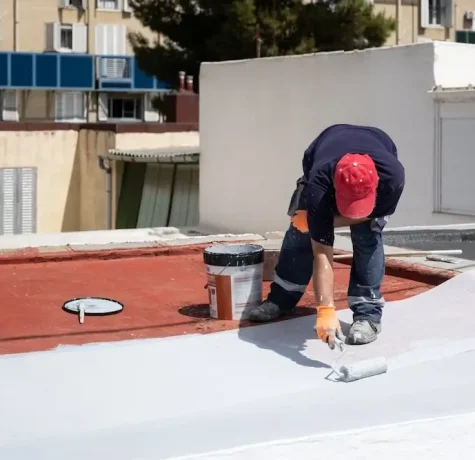 Roofing contractor inspecting a flat roof in Los Lunas, NM to determine whether repair or replacement is needed